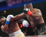 Boxer Jarrell Miller has his hairpiece knocked upward by a punch, then throws it into the crowd